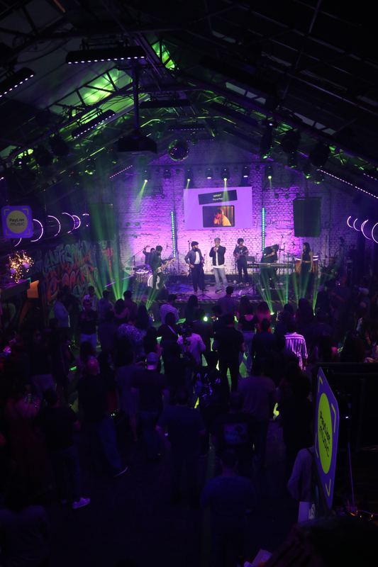 The packed room from the back, green lasers over the crowd